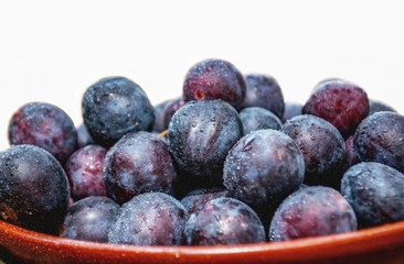 plums in a plate isolated on white
