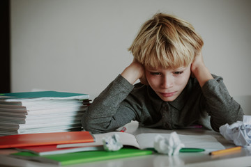 little boy tired stressed of doing homework, bored, exhausted - 228124585