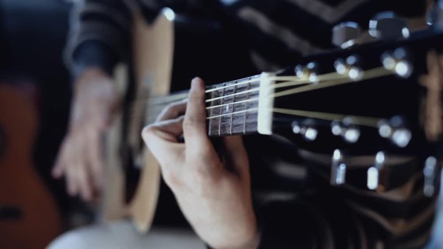 Guitarist playing acoustic guitar close up