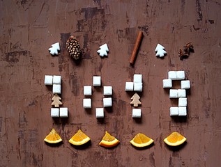 2019 Happy New Year, festive background with the number of the year from pieces of sugar on a dark brown background. Top view.