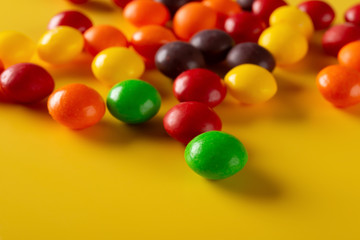 Fototapeta na wymiar studio shot colorful chocolate buttons on yellow background