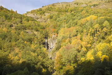 Paisaje de otoño con hojas de colores y cascada en medio