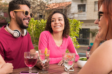 Diverse group of friends having fun at cafe bar outdoor.