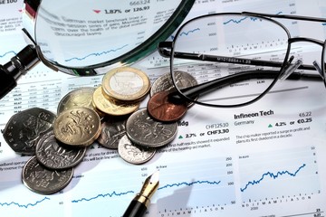 Coins, Fountain Pen, Glasses And Magnifying Glass On Financial