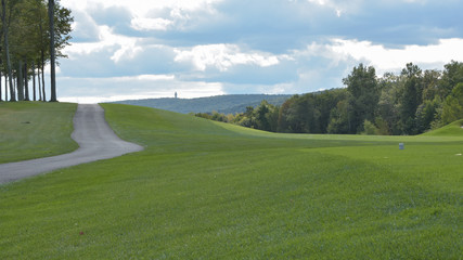wide shot of a golf course with a scenic mountain line on the horizon