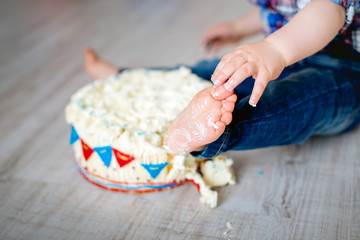 Obraz na płótnie Canvas cake smash, Ein kleiner Junge hat ein Bein in Kuchencreme