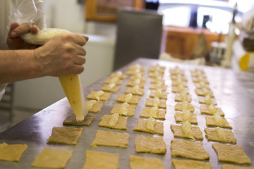 pastelería poniendo crema en pastas