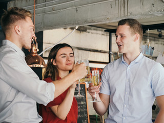 Successful young business men and businesswoman celebrating with champagne in cafe