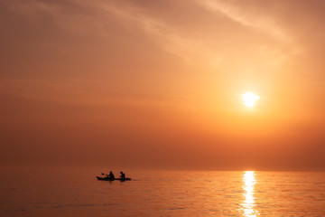 Golden Horizon: Silhouetted Kayakers at Exotic Sunset