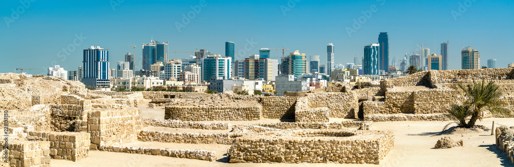 Sticker Ruins of Bahrain Fort with skyline of Manama. A UNESCO World Heritage Site