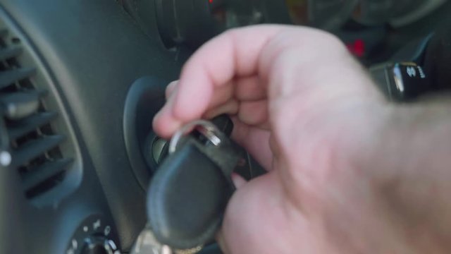 Man's hand puts key in ignition and leaves it there