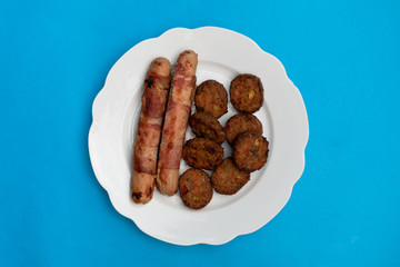 Sausages and Meatballs on a plate with blue background