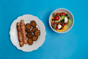 Sausages and Meatballs with a Salad and blue background