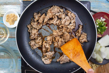 Cooking beef with by chef hands in pan