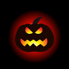 A lit Halloween pumpkin on the dark background.