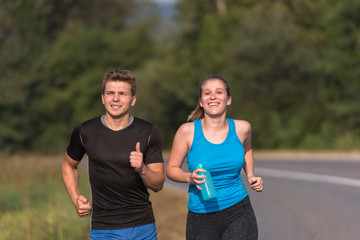 Fototapeta premium young couple jogging along a country road