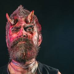 Halloween demon with bloody horns on head
