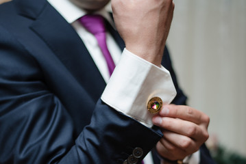 man buttoning cufflink, groom in a jacket, groom's morning, wedding day