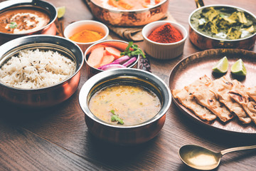 Indian Lunch / Dinner main course food in group includes Paneer Butter Masala, Dal Makhani, Palak Paneer, Roti, Rice etc, Selective focus