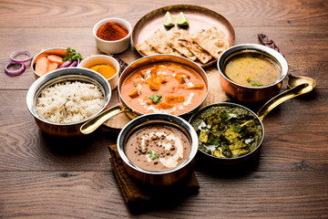 Indian Lunch / Dinner main course food in group includes Paneer Butter Masala, Dal Makhani, Palak Paneer, Roti, Rice etc, Selective focus