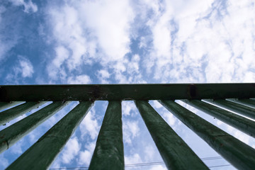 Old wooden fence from bottom to top on the background of clouds
