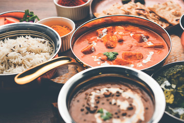 Indian Lunch / Dinner main course food in group includes Paneer Butter Masala, Dal Makhani, Palak Paneer, Roti, Rice etc, Selective focus