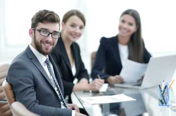 employees sitting behind a Desk.