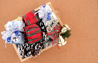 Gifts and decorations in a basket on Christmas Day with a brown backdrop.
