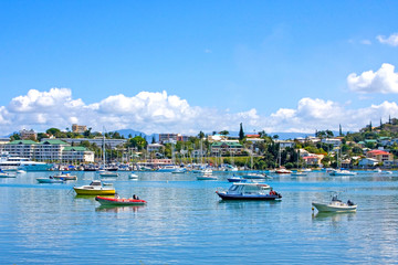 Boats at anchor & city in the background of Noumea harbour, New Caledonia. - obrazy, fototapety, plakaty