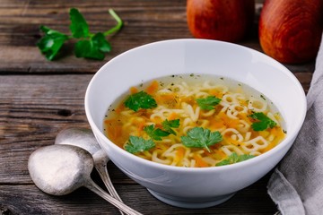 Homemade Chicken and Alphabet Soup with carrots and parsley in bowl