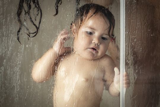 Cheerful mother with baby taking shower