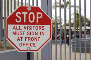 A sign at a closed campus advises visitors to sign in
