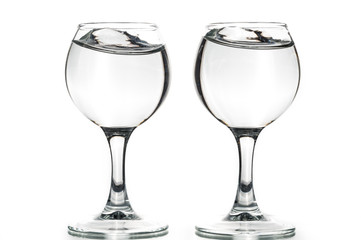 Two round glasses empty or full with waves of liquid on a white background