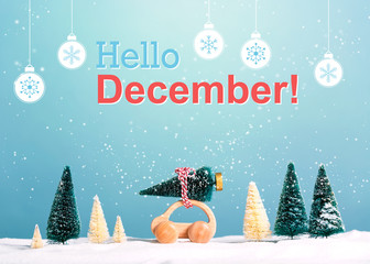 Hello December message with little car carrying a Christmas tree