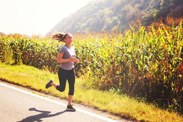 woman jogging along a country road
