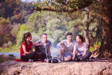 friends smoking hookah on the river bank