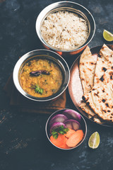 Dal Tadka Fry / Indian Lentil Curry served in a bowl with rice and roti, selective focus