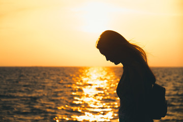 Fototapeta premium Woman standing,Sunset sky over horizon.