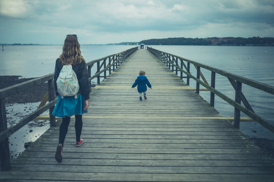 Toddler and mother walking on pier