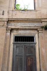 Fototapeta na wymiar Vintage colonial wooden door frame and rustic concrete building facade