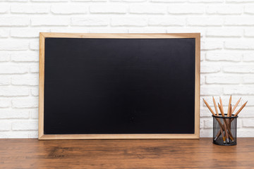 blackboard and a pencil on wooden background