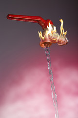 Faucet from which flows a very hot water flow / Faucet from which water flows so hot it generates a flame