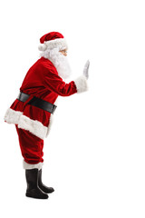 Full length profile shot of Santa Claus waving