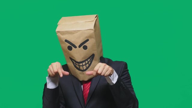 concept of emotion, gestures. a man with a package on his head, with a painted smiley angry, sly, gloating
