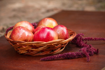 Apples in a basket on a wooden table