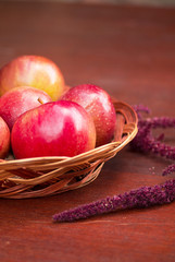 Apples in a basket on a wooden table