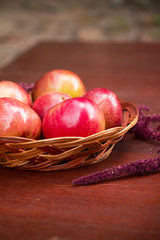 Apples in a basket on a wooden table