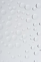 close-up view of transparent water drops on light grey abstract background