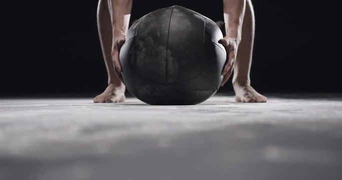 Man doing crossfit with medicine ball in studio