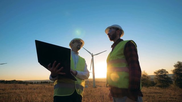 People in uniform checking windmills, close up.